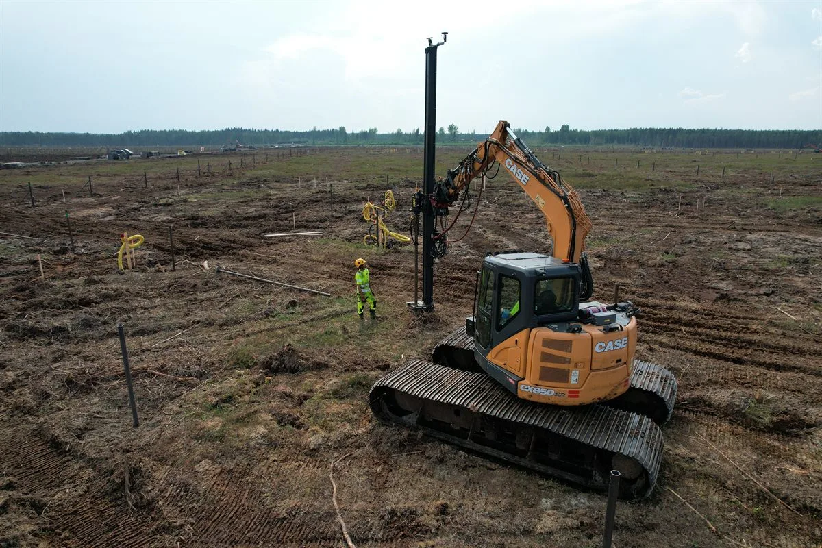 Excavator installing piles